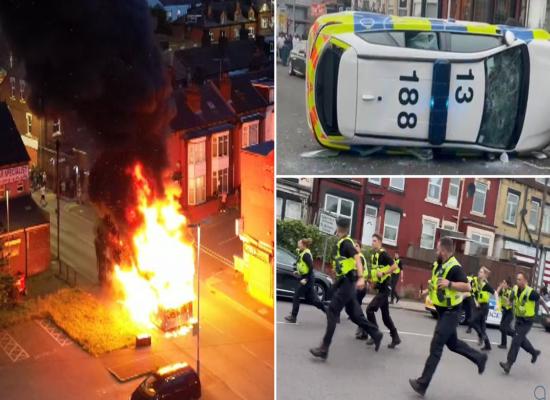 Bus set on fire and police car flipped over as riot breaks out in Leeds